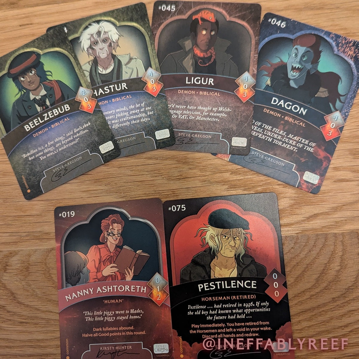 A selection of Good Omens trading cards, photo taken by a fan.