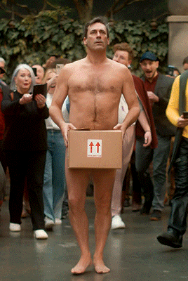 Gabriel walking naked carrying a box.
