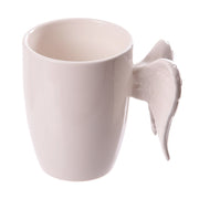 A white coffee mug featuring angel wings.